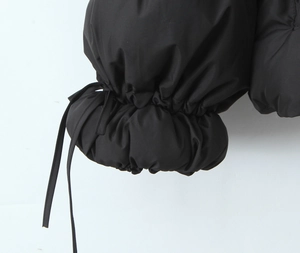 Detail of adjustable drawstring cuffs on black quilted puffer jacket for women