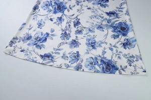 Detailed view of the soft white fabric featuring elegant blue floral print patterns