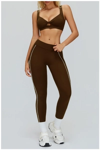 Dettaglio del set yoga marrone con strisce laterali e reggiseno sportivo allacciato al collo