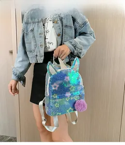Detail of glitter unicorn backpack with colorful sequins and purple pompom charm