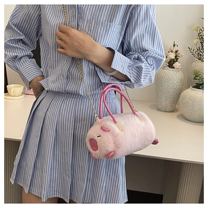 Dettaglio della borsa cilindrica in peluche rosa con catena in metallo e dettagli 3D
