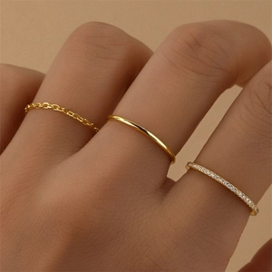 Detailed view of three gold S925 silver rings including chain, plain, and CZ stone styles