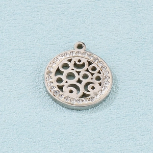 Détail d'un pendentif géométrique argenté avec motif ajouré et strass brillants