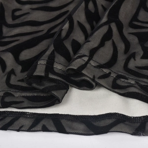 Gros plan détaillé du tissu en maille noire semi-transparente avec motif floqué zébré