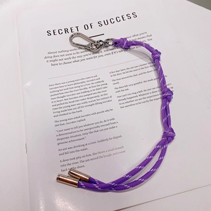 Porte-clés en paracorde tressée violette avec mousqueton sur un magazine esthétique