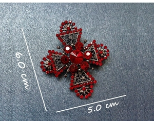 Detailed view of vintage cross brooch with red rhinestones measuring 6.0 cm by 5.0 cm