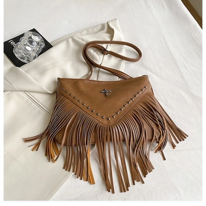 Détails d'un sac en similicuir marron avec des franges bohèmes et des rivets en métal
