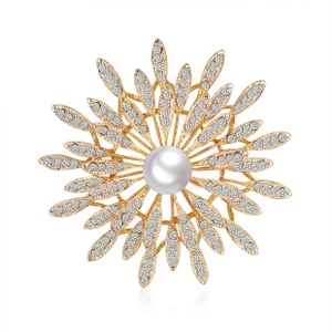 Detailed close-up of golden flower brooch with a central white pearl and sparkling crystals