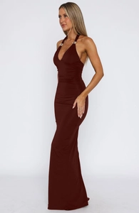 Close-up of elegant gold metal ring detailing on a deep red backless maxi dress