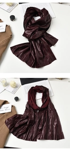 Vista piana di sciarpa plissettata rosso vino con texture lucida, laptop e scena lifestyle