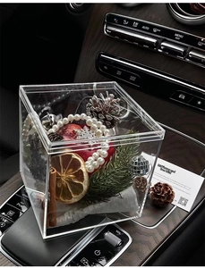 Detailed Christmas acrylic gift box with pine cones and berries in luxury car interior