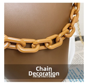 Close-up of brown bucket bag featuring chunky link chain detail and pebbled texture