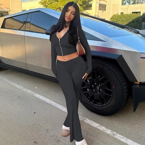 Detail of black long sleeve zip-up hoodie and high waisted flare pants set on model