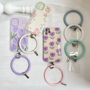 Flat lay of floral phone cases and colorful silicone wristlet strap rings with metal clips