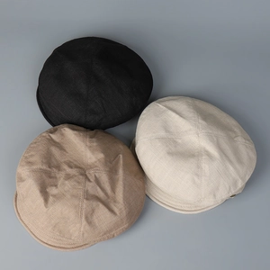 Vue détaillée de la texture du tissu en lin sur trois casquettes plates minimalistes et colorées