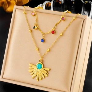 Double layer gold necklace featuring colorful gems and a sunburst turquoise pendant
