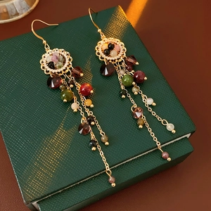 Close-up of vintage flower tassel earrings with colorful beads and golden metal finish