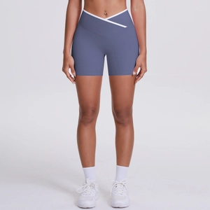 Detail of high-waisted yoga shorts with crossover V-cut waist and white contrast piping