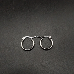 Close-up of small silver stainless steel hoop earrings with polished mirror finish