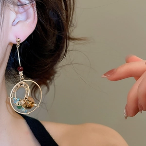 Detail of vintage bohemian dangle earrings with crystal beads and round metal rings on model
