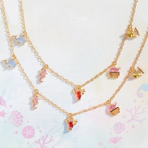 Detail of double-layer gold necklace with colorful seahorse and jellyfish marine charms