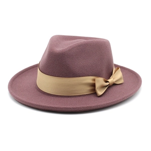 Close-up of the elegant gold satin ribbon and bow detail on the purple wool fedora hat