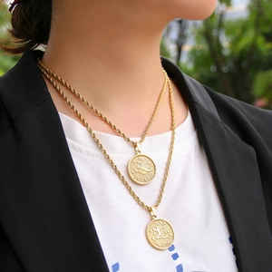 Close-up of 18K gold-plated zodiac necklaces featuring Scorpio and Sagittarius coin pendants