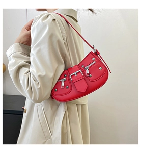 Detail of red vintage motorcycle underarm bag with silver studs and zipper accents