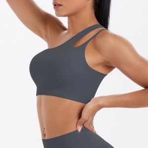 Detail view of one-shoulder sports bra with unique cutout straps and matte finish