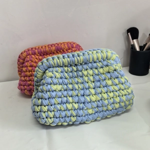 Handmade crochet cloud clutch bags in colorful woven fabric shown from a front angle