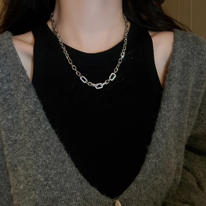 Close-up of geometric silver chain necklace with shimmering zircon-inlaid links