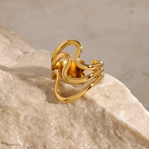 Polished 18K gold plated irregular wave ring on natural rock with open adjustable band