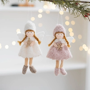 Close-up of pink and white felt Christmas angel hanging ornaments on pine branches