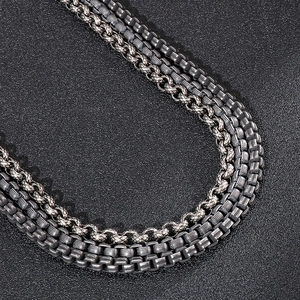 Close-up of layered stainless steel keel and square box chains with vintage finish