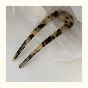 Detail showing acetate U-shaped hair fork with classic tortoiseshell pattern and smooth finish