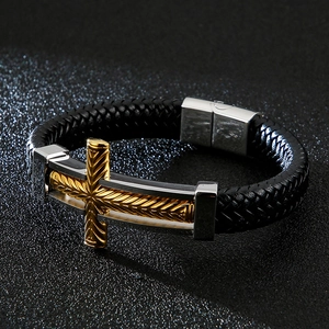 Detail of cross element on woven leather bracelet with magnetic stainless steel clasp