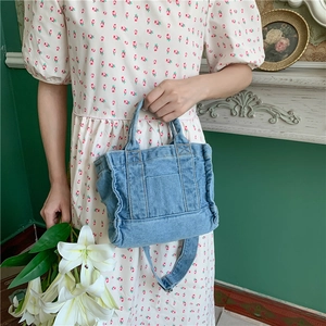 Detailed view of a vintage blue denim tote bag with external pockets and shoulder strap