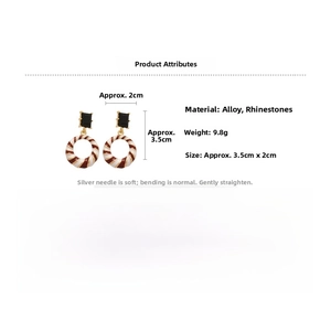 Detail shot of geometric drop earrings featuring golden frames and red white striped hoops