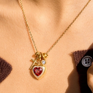 Goldene Herzkette mit rotem Zirkon und Kreuz-Design an einem weiblichen Modell