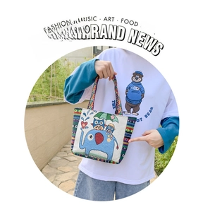 Detail of embroidered canvas tote bag with elephant and owl ethnic patterns