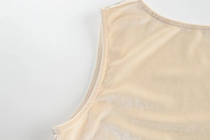 Détail macro des coutures et texture velours brillant sur cette robe couleur champagne