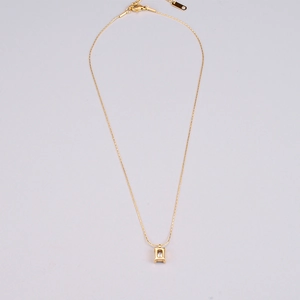 Macro detail of a square clear zircon pendant on a delicate gold titanium steel chain