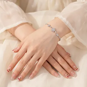 Sparkling silver flower bracelet with zircon inlays worn on wrist against a soft background
