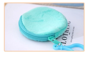Detailed close-up of mint green plush round coin purse with matching zipper and blue hook