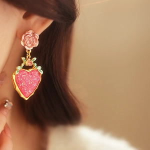 Detail of vintage pink rose flower stud earrings with shimmering heart strawberry pendants