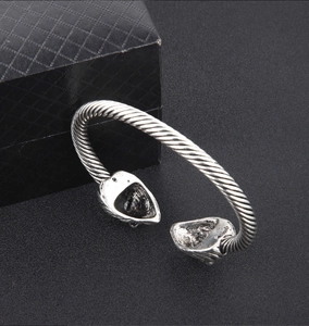 Detailansicht des silbernen Löwenkopf Armreifs im Vintage-Design mit gedrehtem Metall und Punk-Stil