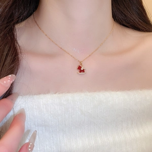 Detail of a gold necklace featuring a red rocking horse pendant with sparkling zircons
