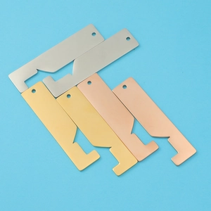 Polished stainless steel house pendants in gold, silver and rose gold on blue backdrop