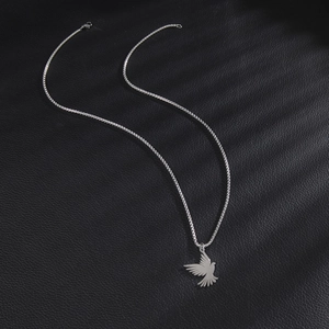 Silver stainless steel necklace with flying bird pendant on black leather surface