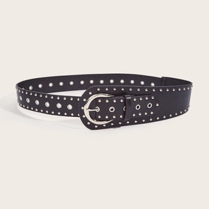 Close-up of black punk belt with silver metal rivets and buckle on beige background